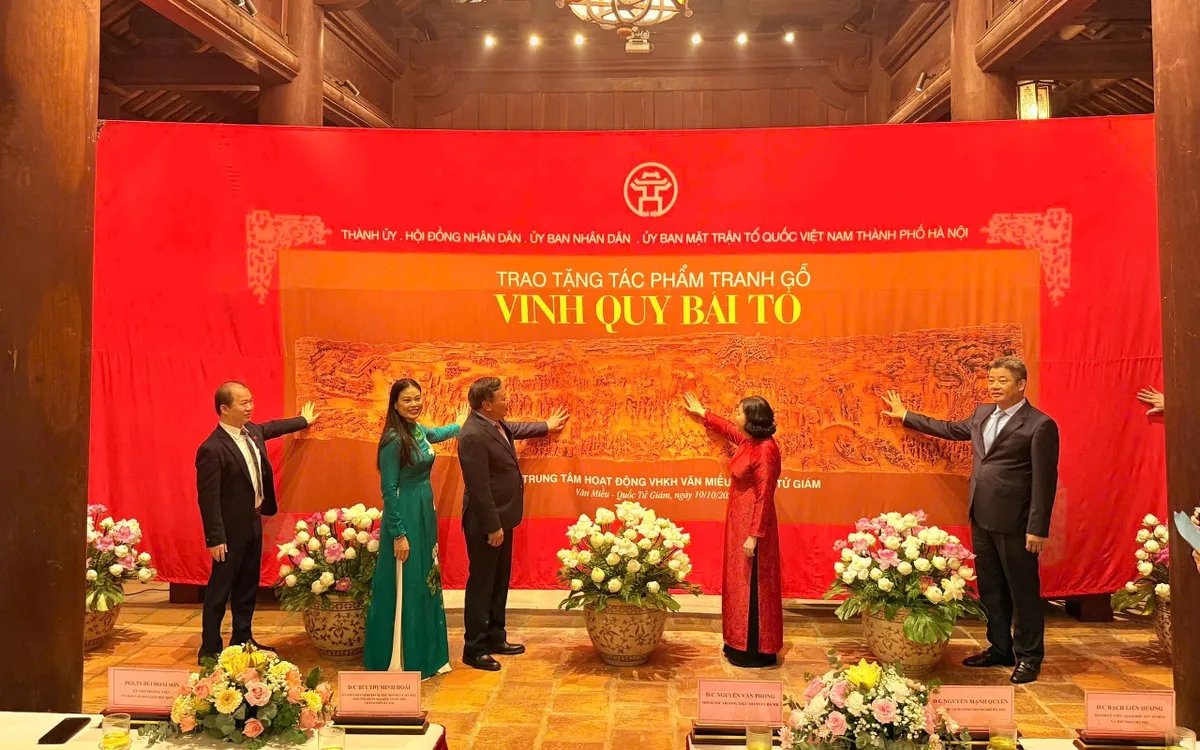 Lãnh đạo TP Hà Nội và các đại biểu trao tặng tranh gỗ "Vinh quy bái tổ" cho Trung tâm Hoạt động Văn hóa Khoa học Văn Miếu - Quốc Tử Giám.