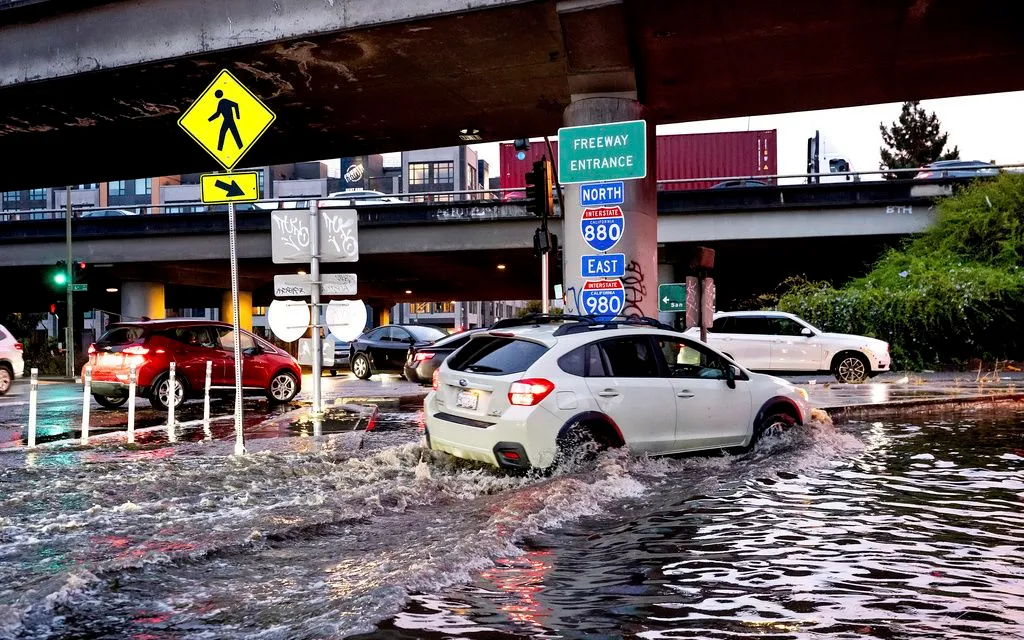 Một chiếc ô tô di chuyển qua đoạn đường cao tốc bị ngập ở Oakland, bang California, ngày 13/10/2025 (Ảnh: AP)
